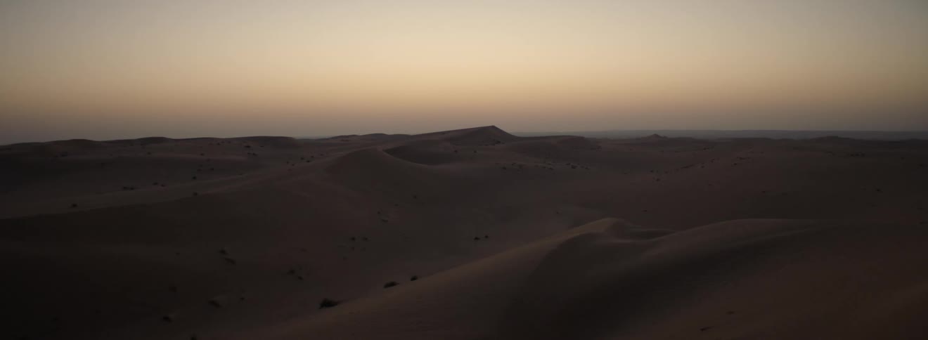 View of desert with sand dunes at dusk