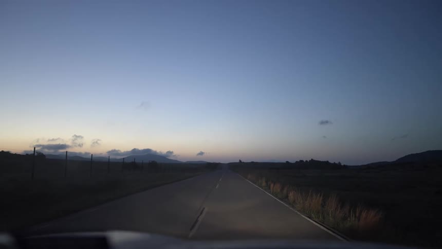 Traveling down a two lane country road with headlights on