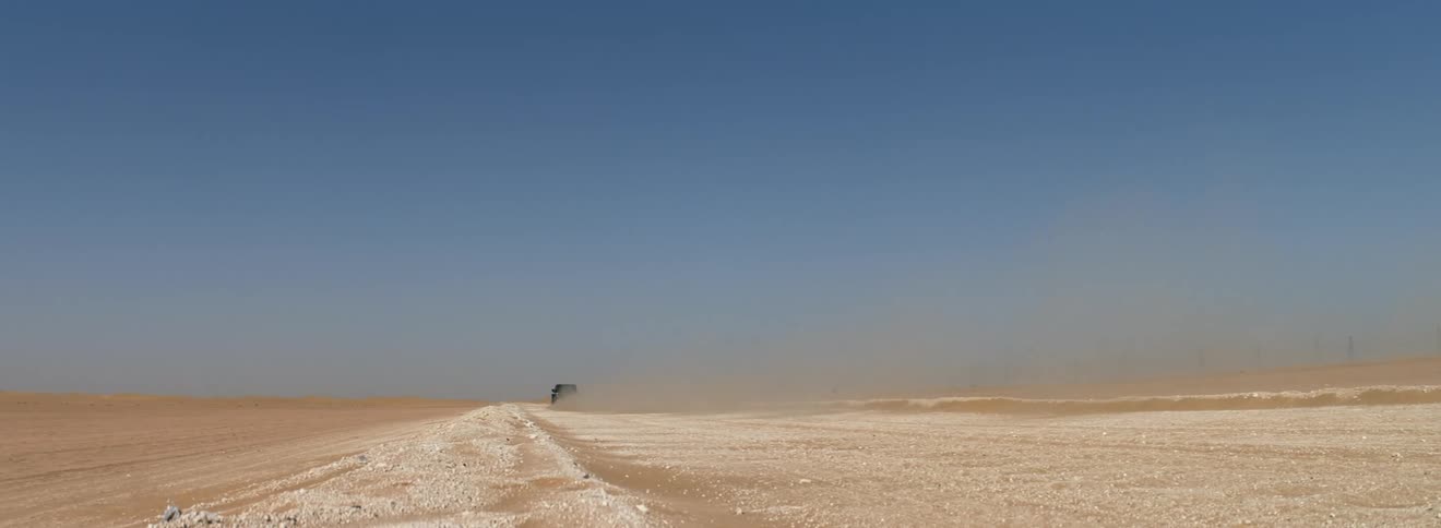 A jeep speeds across the desert