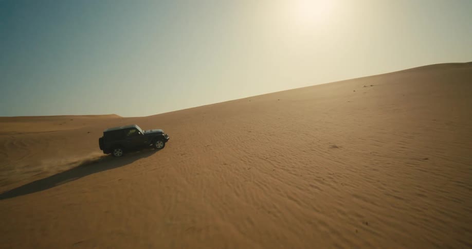 Car driving across sand