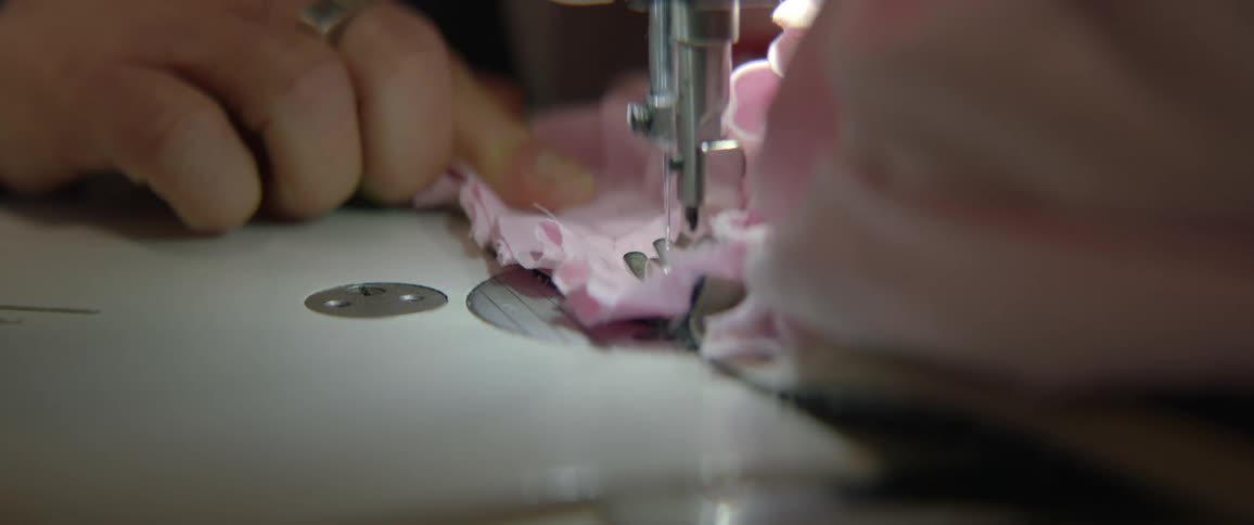 A person is using a sewing machine to sew a ruffle