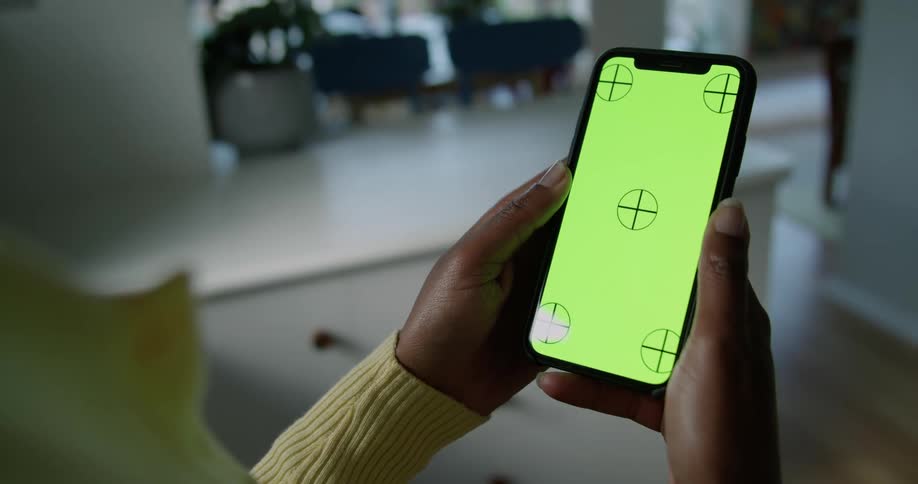 Someone is holding a cell phone in both hands as the look at it
