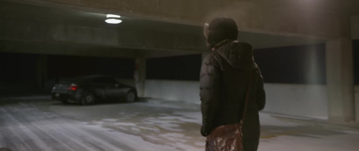 A person is walking in a parking lot