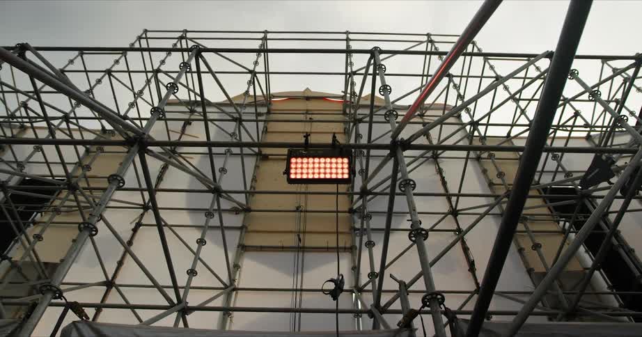 Scaffolding is in place in the front of a building on an overcast day