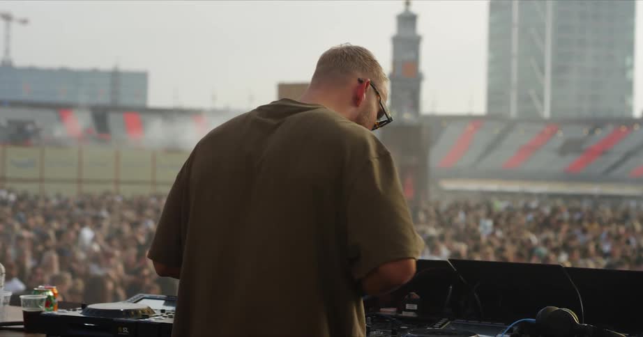 A musician is performing on stage for a large crowd