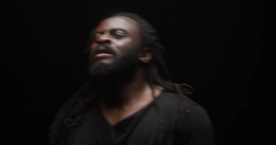 A man in a room dancing with a black background