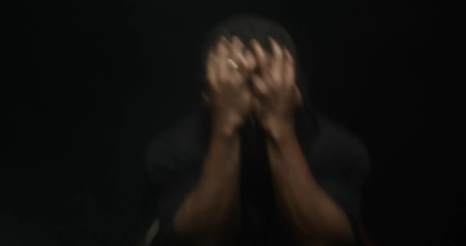 A man in a room with a ring holding his head with lights flashing