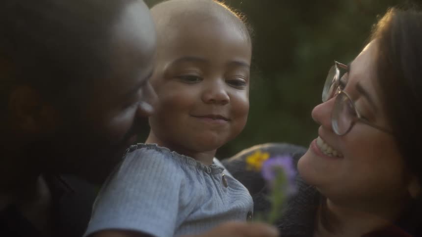 Parents hold their daughter outside