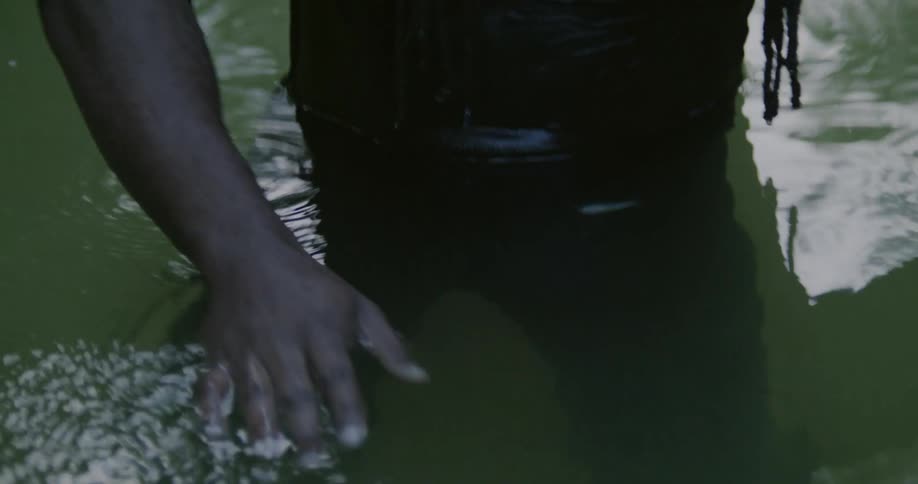 A man standing in water with reflections