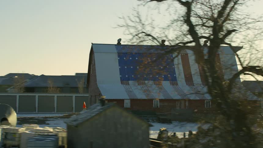 A view of a barn on a large farm