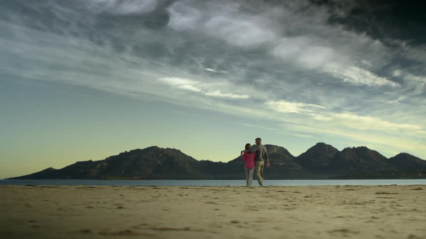 Two people walking on the beach