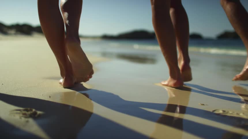 A group of people walking at the beach