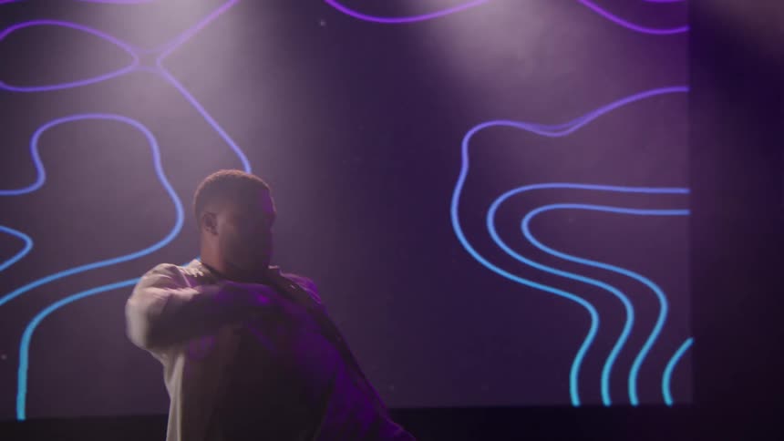 A man is doing interpretive dance on a stage