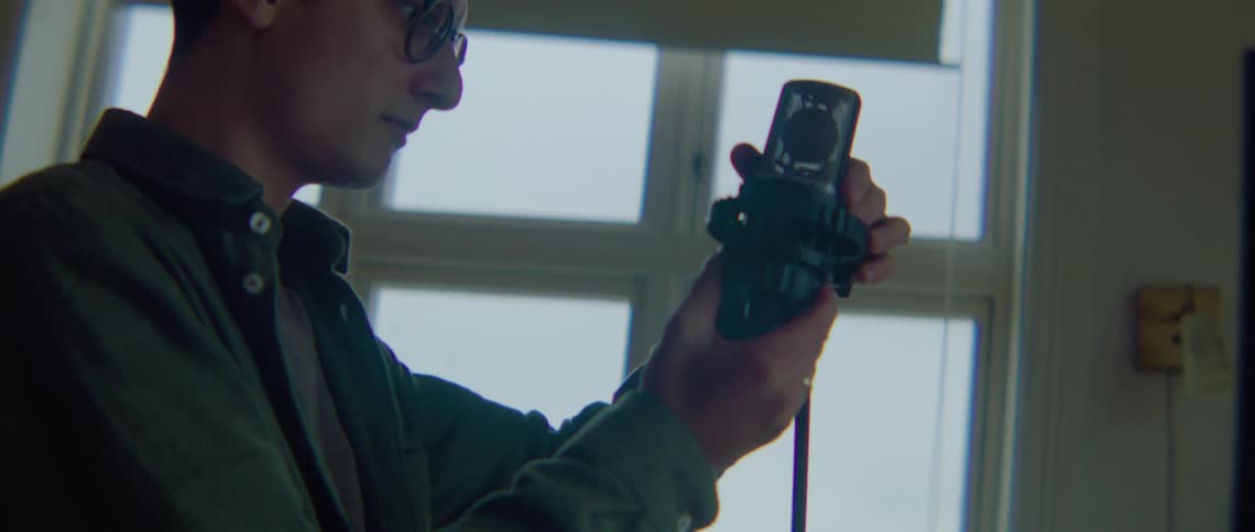 A man in a room is setting up a microphone on a foggy and dreary day