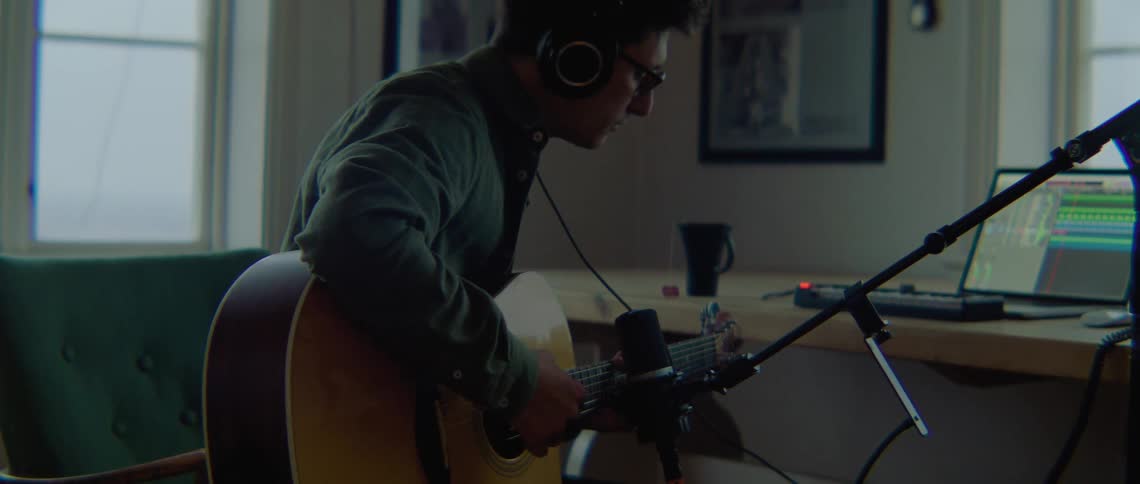 A man playing guitar in a room