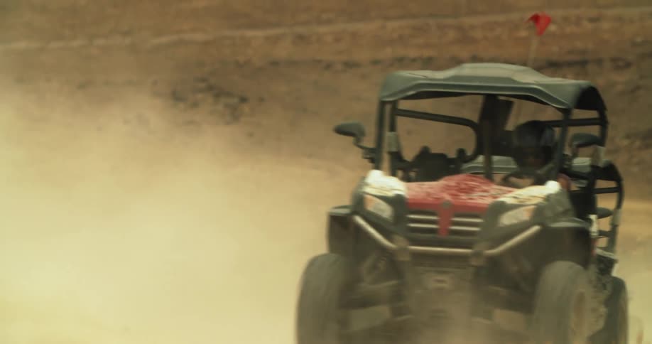 People with helmets racing buggies