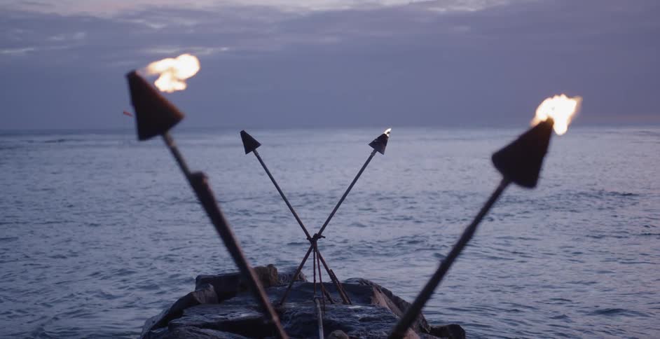 A small boat in the water is covered with torches