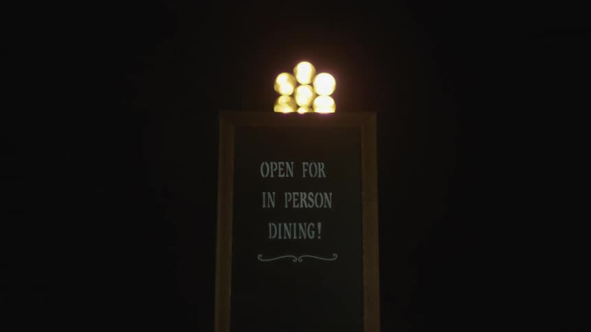 Lights flash in the darkness illuminating a sign