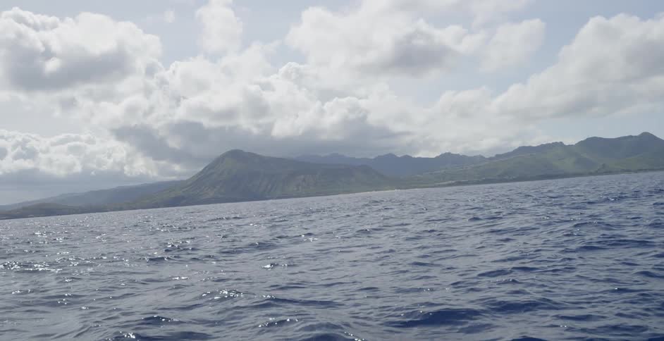 Water rolling near a mountain on a cloudy day