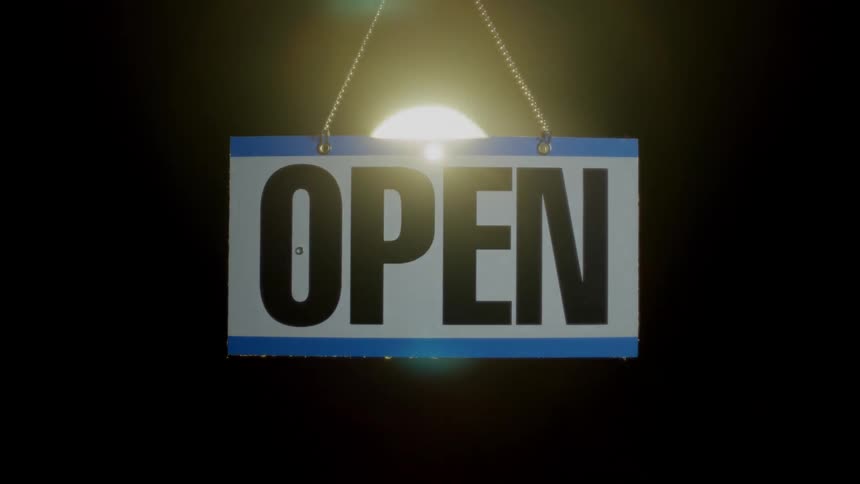 A sign with spotlights and a black background