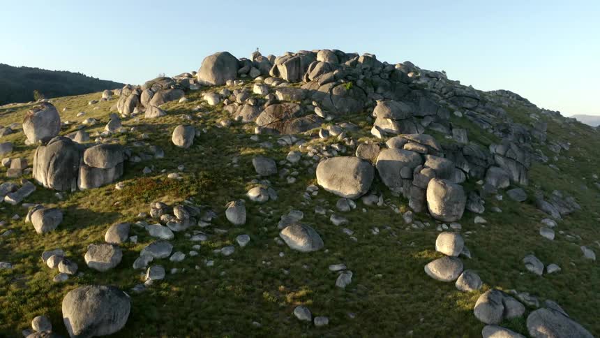 Aerial view of rocky hill under blue sky