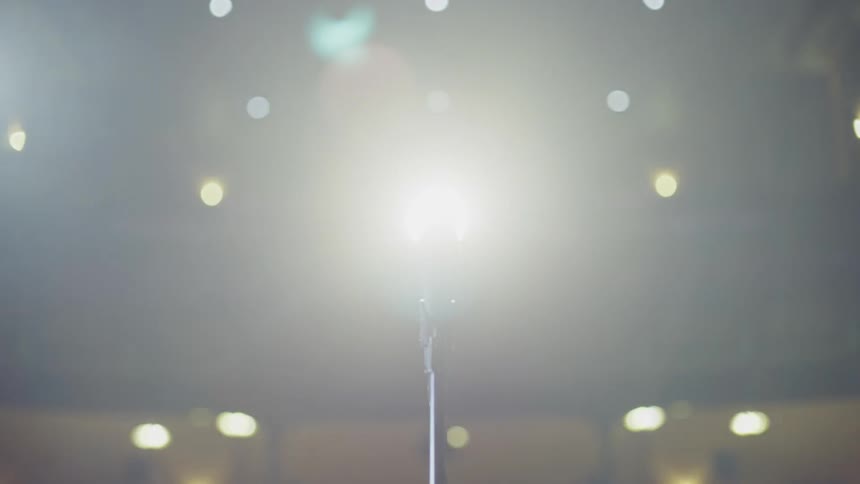 The curtain opens on stage to a blinding light