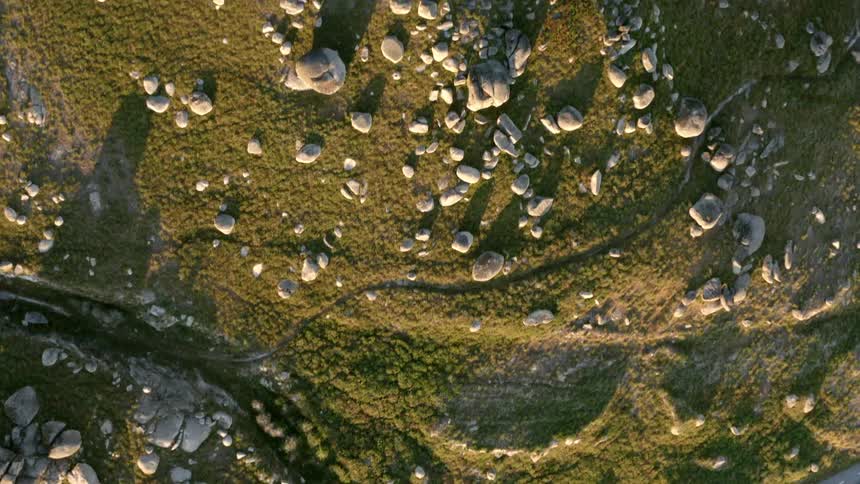 An aerial view of a road going through a rocky field