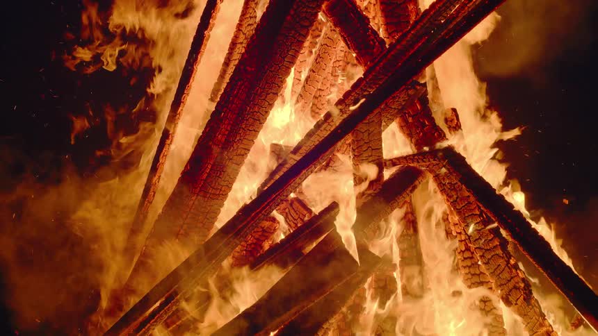 A large bonfire is burning at night