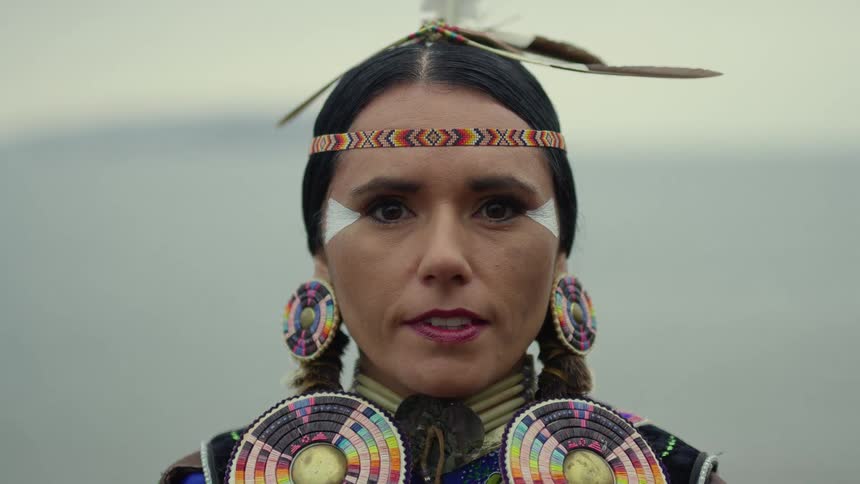 A portrait of a native woman standing outdoors