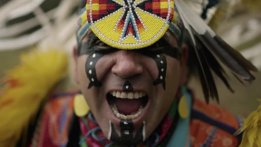 A man in a costume spins around looking angry