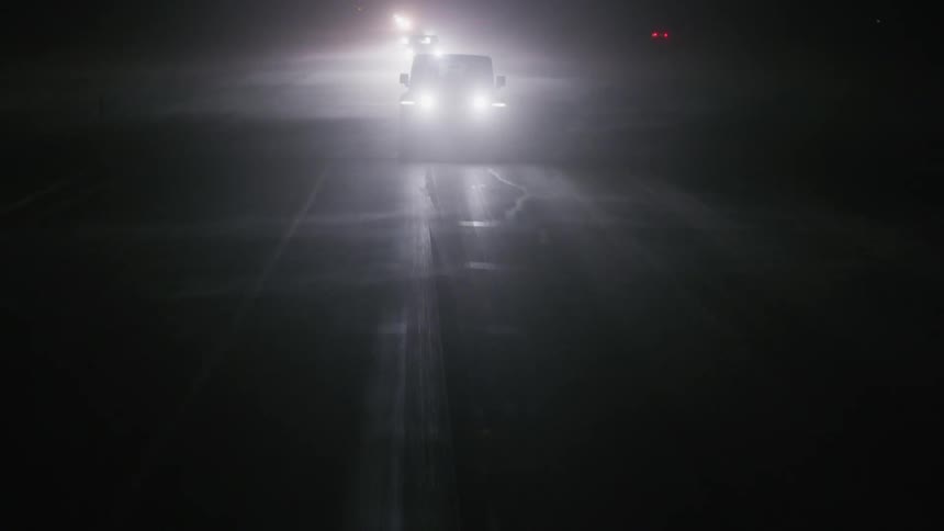 Cars driving down a road at night