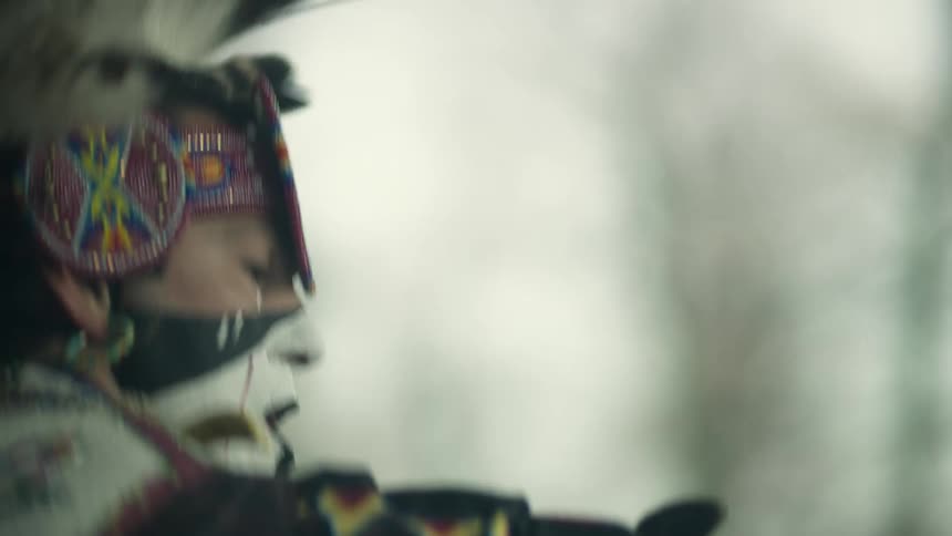 Native american performs dance wearing traditional garb