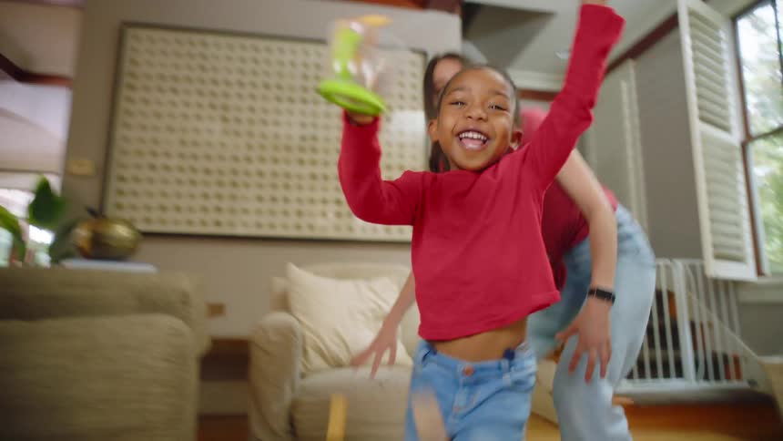 A teenager jokingly chases a young girl through the house