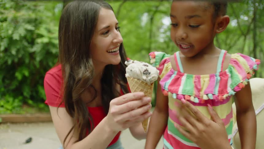 A mother giving her daughter an ice cream cone