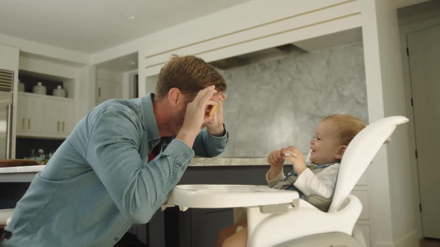 A man plays around with son by playing crackers over his eyes