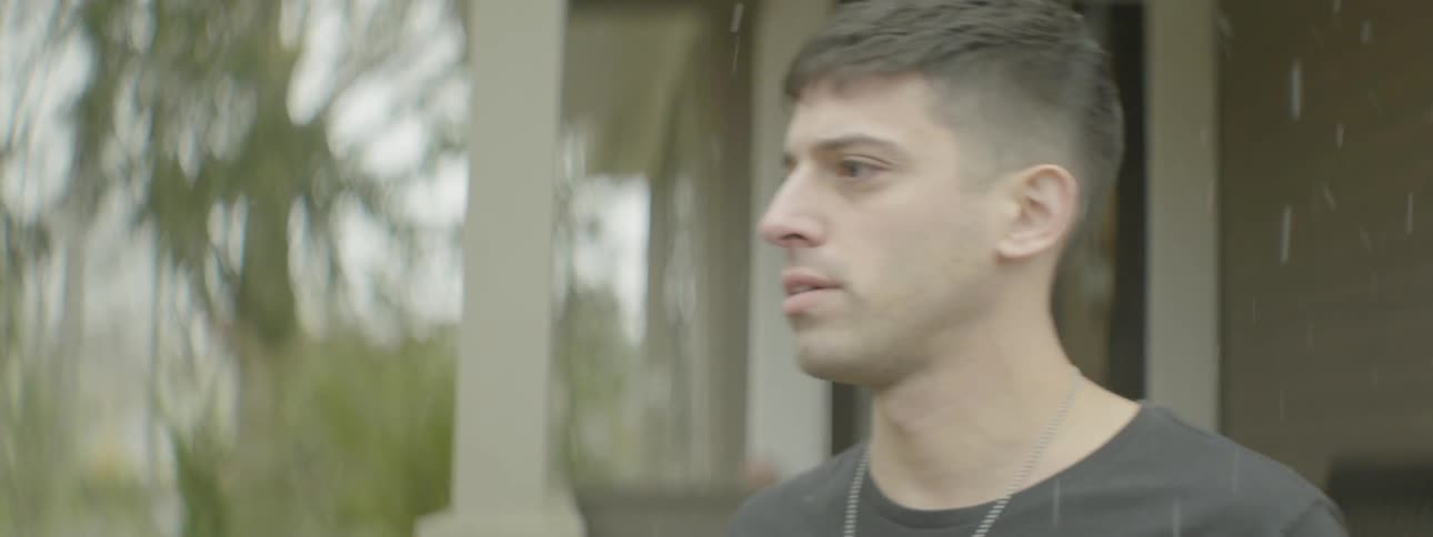 Man walks out of house and stands outside while snow falls