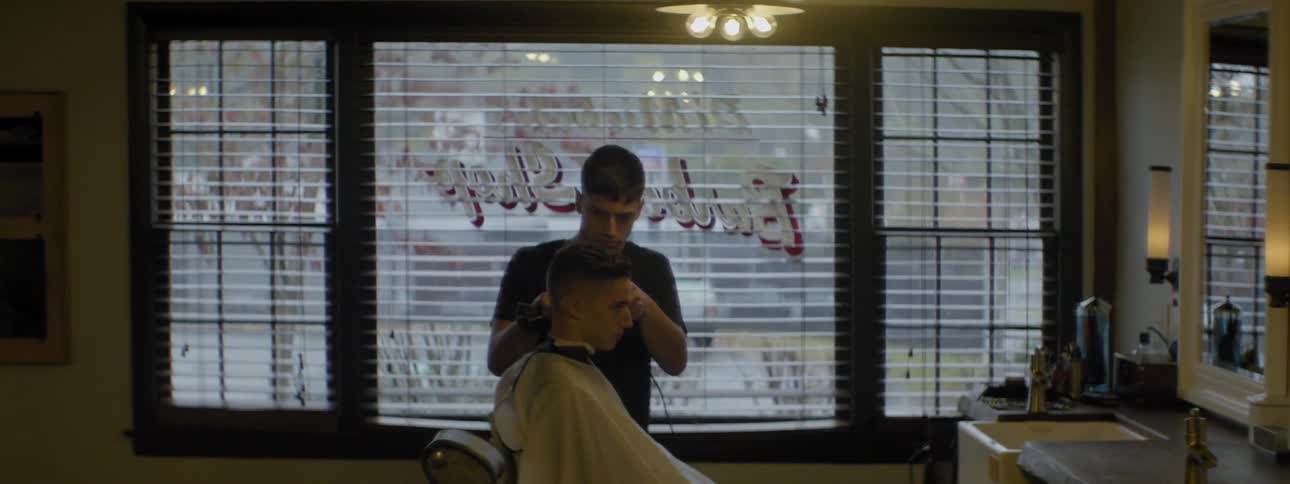 A barber trims someone's hair