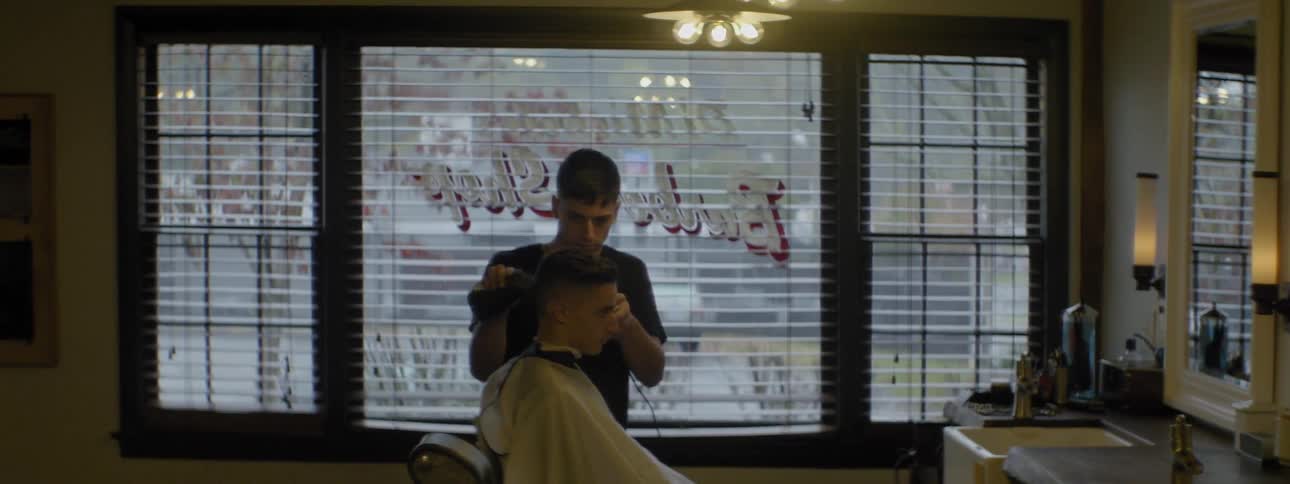 A man is getting a haircut in a barber shop