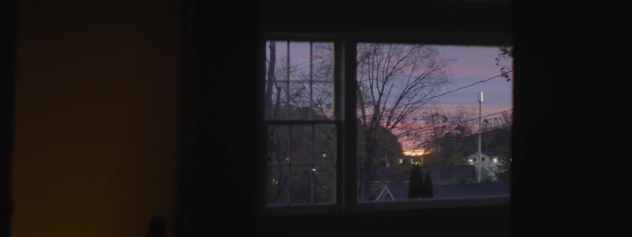 View of a city through a window at sunset