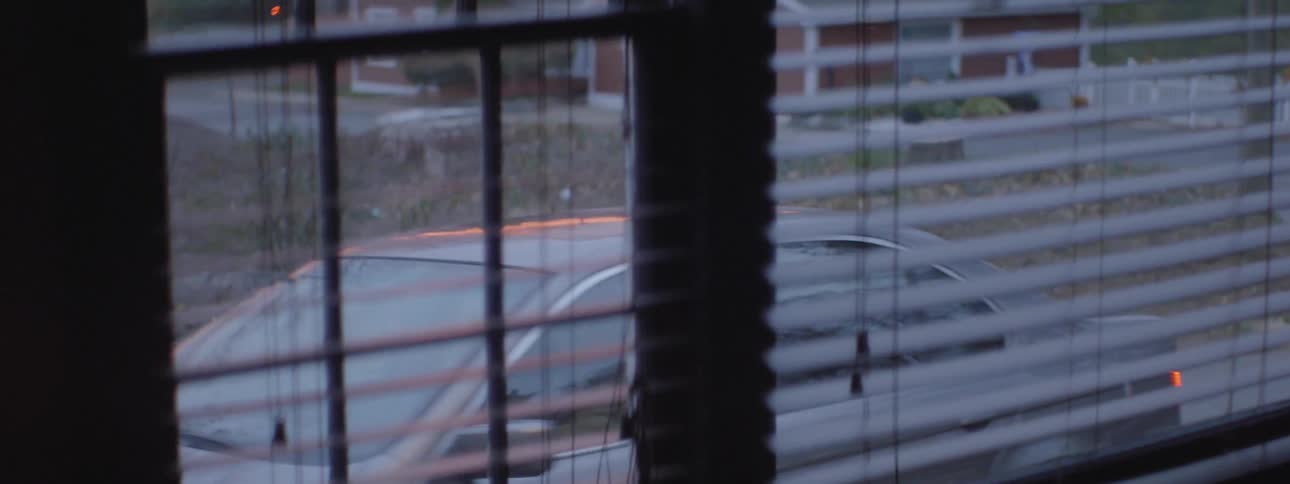 A gray car pulls into a shop parking lot
