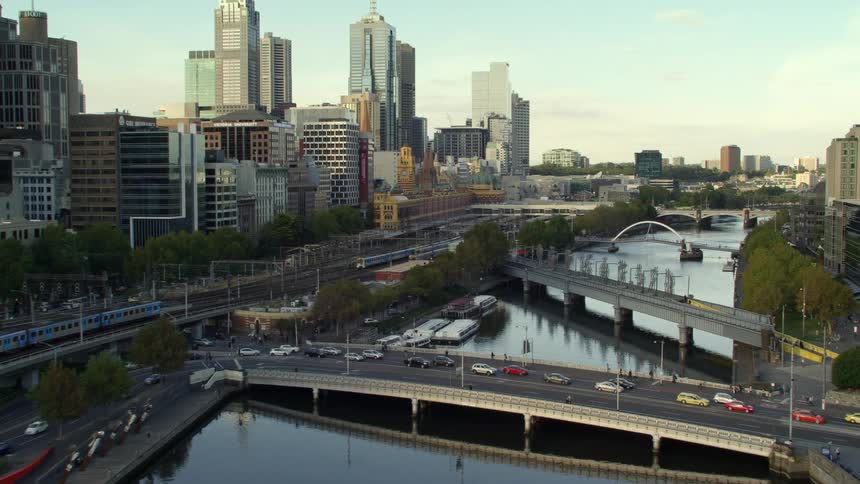 Aerial view of traffic on the bridge over a river in the city at evening