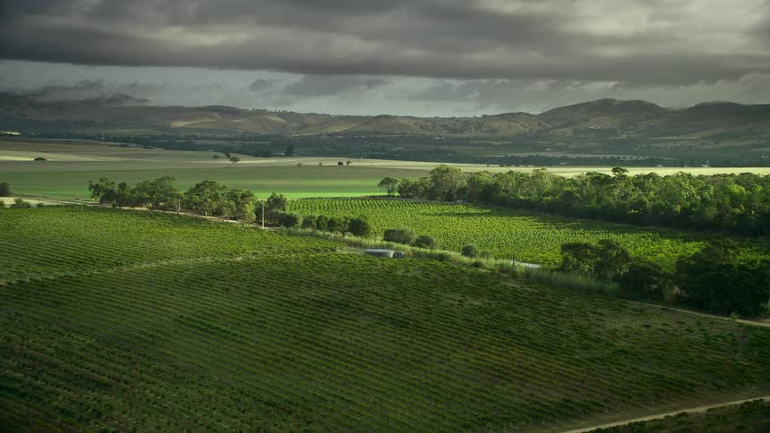 The clouds reveal sunshine on farmland split by a road