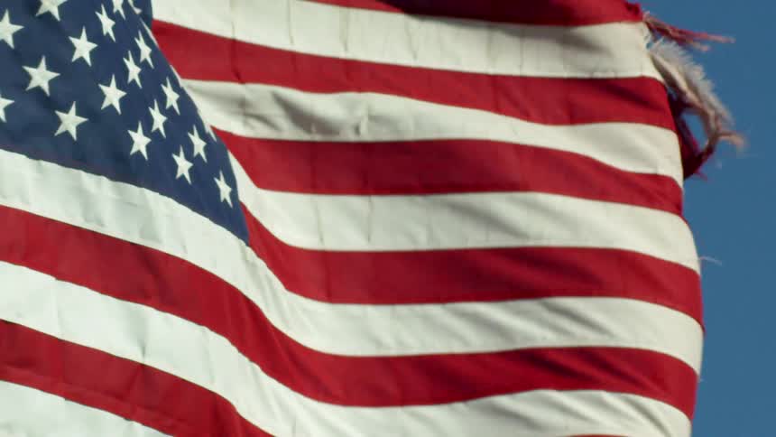 A tattered american flag blows in the wind