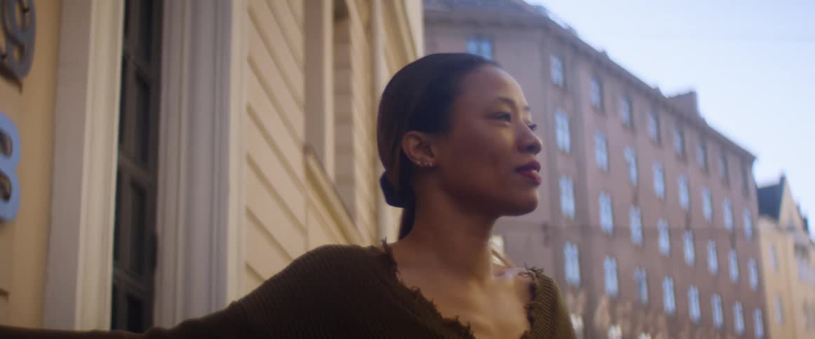 A woman exits the building to get air and then goes back in