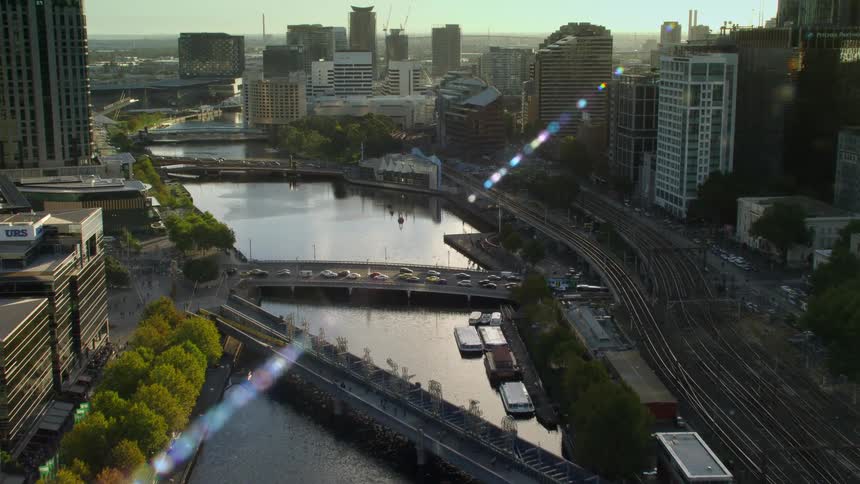 Aerial view of traffic on the bridges over a river through the city at sunset