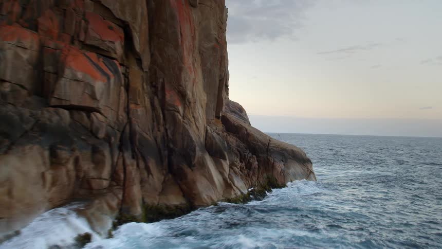Waves crash against the mountains on the shore