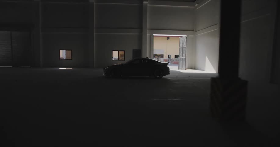 Black car drives inside the dark building
