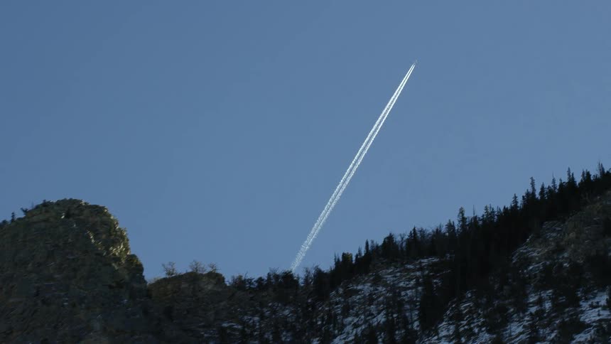 A rocket is rising in the sky above the mountain