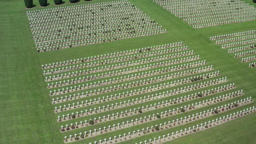 A cemetery with grass trees and white crosses