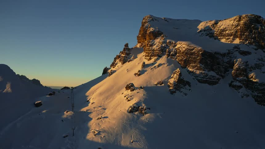 An aerial view of a snowy mountain range in the wilderness on a winter morning
